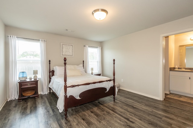 bedroom with dark wood finished floors, baseboards, and multiple windows