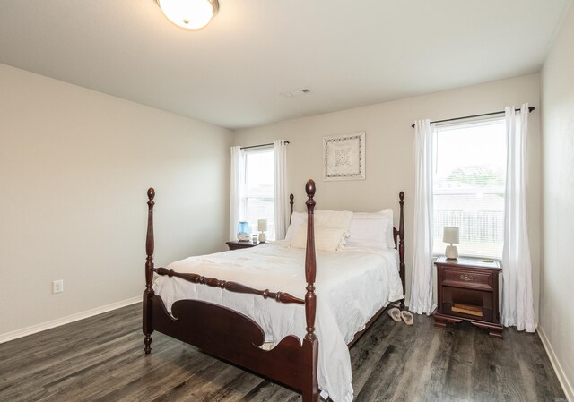 bedroom with visible vents, dark wood finished floors, and baseboards