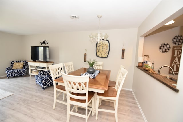 135 Hillview Dr Unit 109, Fairfield Bay, AR 72088 - dining room with an inviting chandelier, baseboards, light wood-style flooring, and visible vents