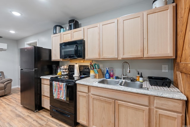 kitchen with light wood-style flooring, light brown cabinetry, black appliances, a wall mounted AC, and a sink