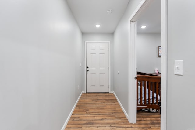 doorway to outside with wood finished floors, recessed lighting, and baseboards