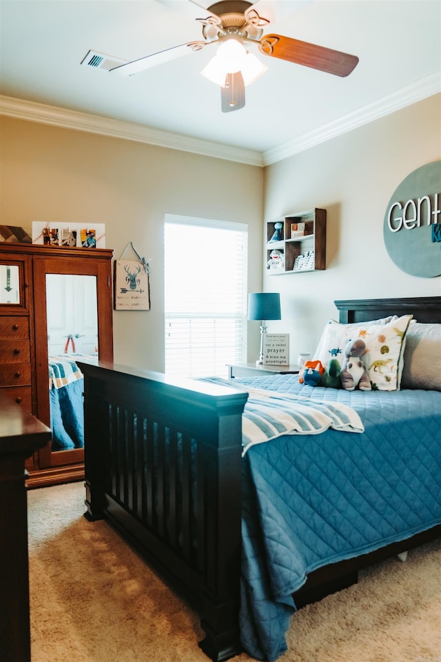 carpeted bedroom with visible vents, a ceiling fan, and crown molding