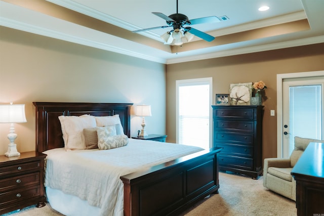 bedroom featuring ornamental molding, light carpet, visible vents, a raised ceiling, and a ceiling fan