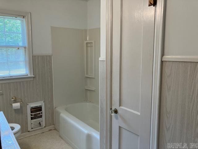full bathroom with heating unit, a wainscoted wall, and toilet