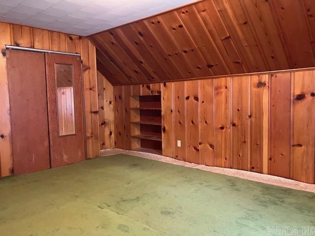 additional living space featuring wood walls and lofted ceiling