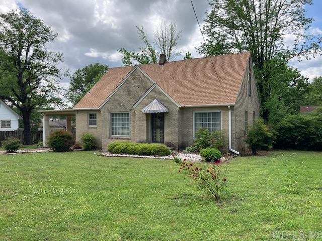 ranch-style house with a front lawn, brick siding, and fence