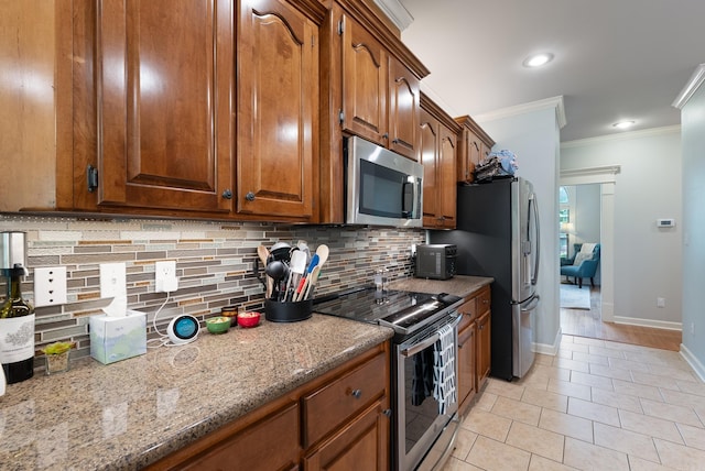 kitchen featuring crown molding, appliances with stainless steel finishes, decorative backsplash, and baseboards