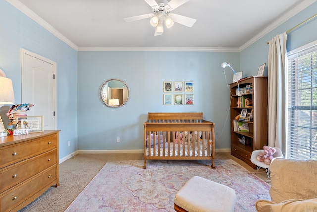 bedroom with carpet flooring, a nursery area, a ceiling fan, baseboards, and ornamental molding