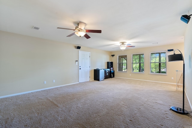 unfurnished living room featuring carpet flooring, a ceiling fan, baseboards, and visible vents
