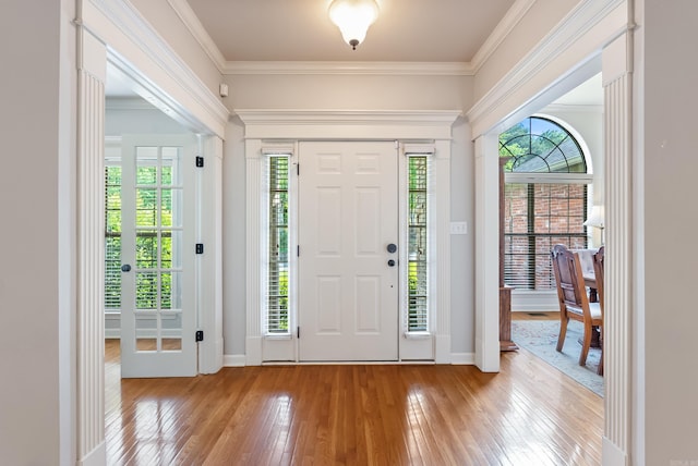 foyer featuring ornamental molding, hardwood / wood-style flooring, and a wealth of natural light