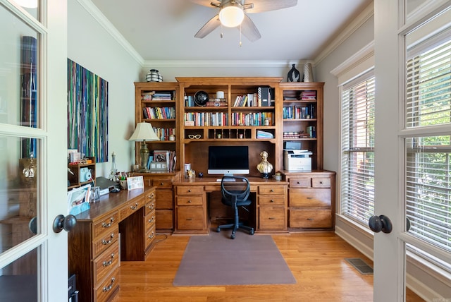 home office with visible vents, ornamental molding, built in study area, a ceiling fan, and light wood finished floors