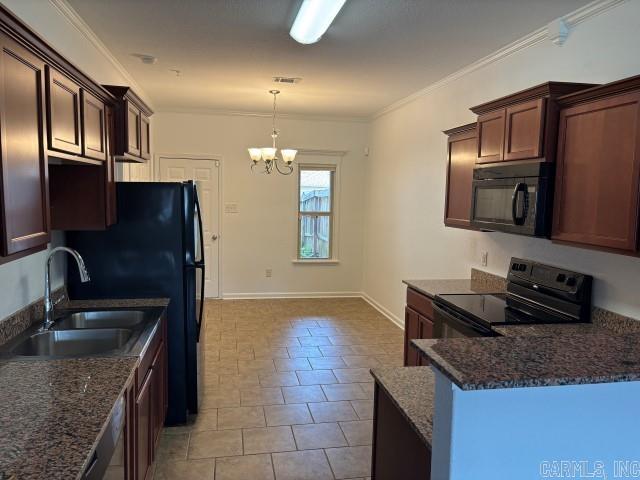 kitchen featuring an inviting chandelier, a sink, black appliances, pendant lighting, and ornamental molding