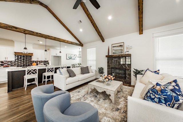 living room featuring beam ceiling, dark wood-type flooring, visible vents, and a high end fireplace