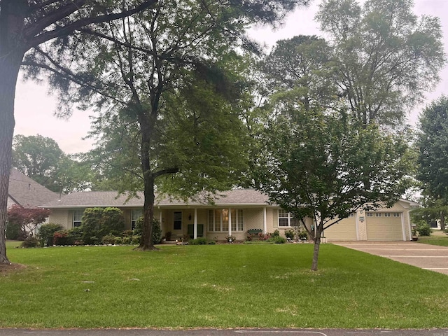 ranch-style home featuring a front yard, an attached garage, and concrete driveway