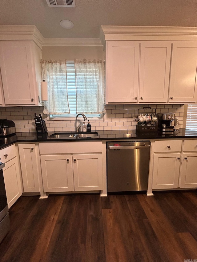 kitchen with stainless steel dishwasher, crown molding, a sink, and dark countertops