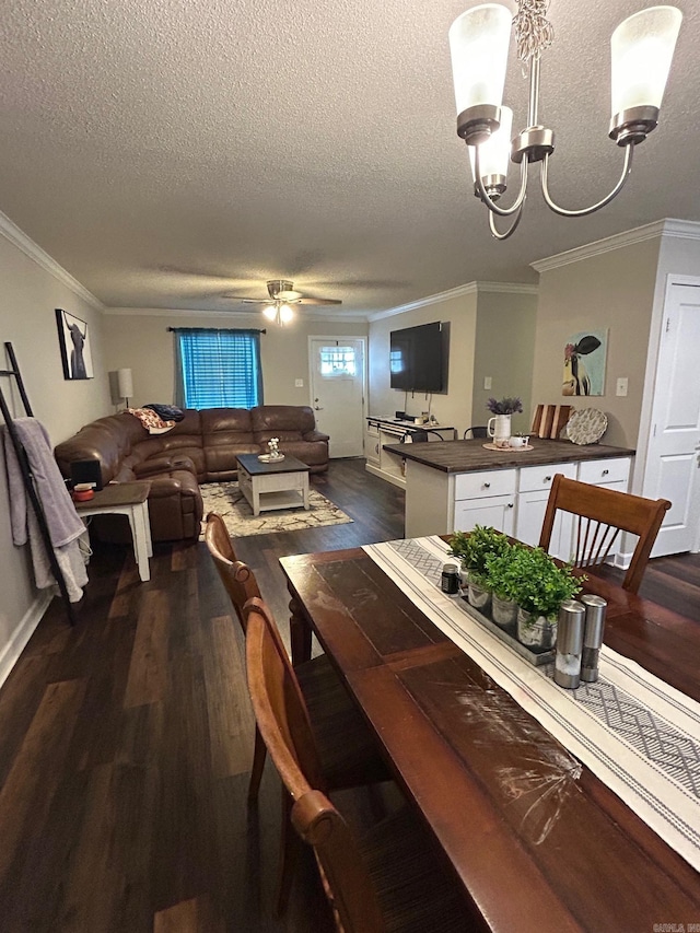 dining space featuring a textured ceiling, ornamental molding, dark wood-style floors, and ceiling fan with notable chandelier