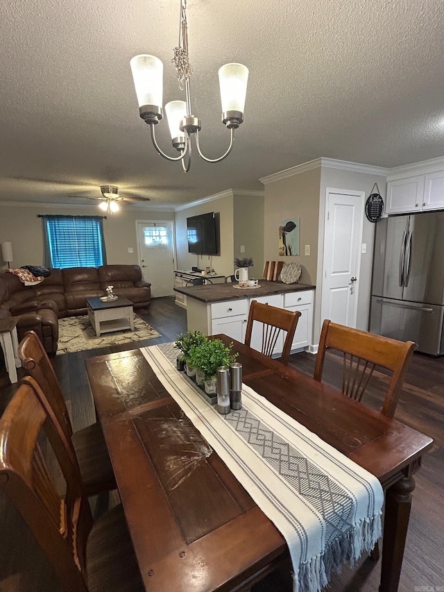 dining room with dark wood-style floors, a chandelier, a textured ceiling, and crown molding