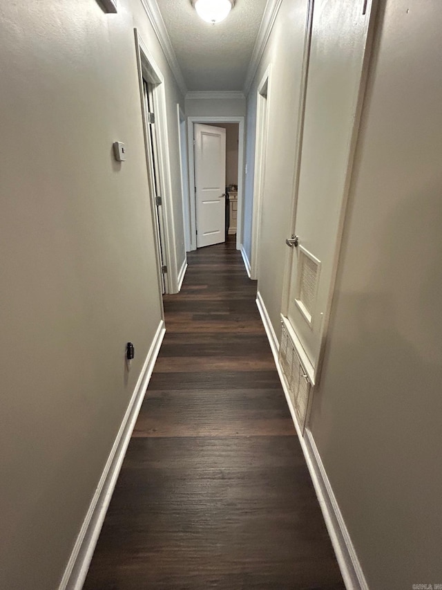 corridor with visible vents, ornamental molding, dark wood-style floors, and baseboards
