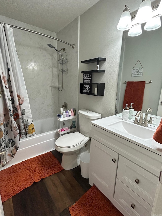 bathroom with wood finished floors, shower / bath combo with shower curtain, toilet, vanity, and a textured ceiling
