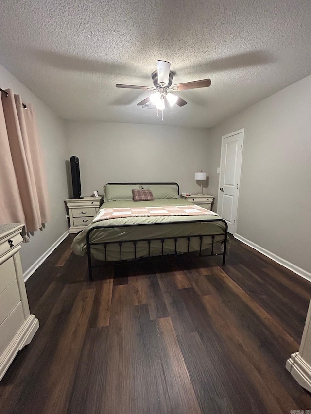 bedroom with a textured ceiling, wood finished floors, and baseboards