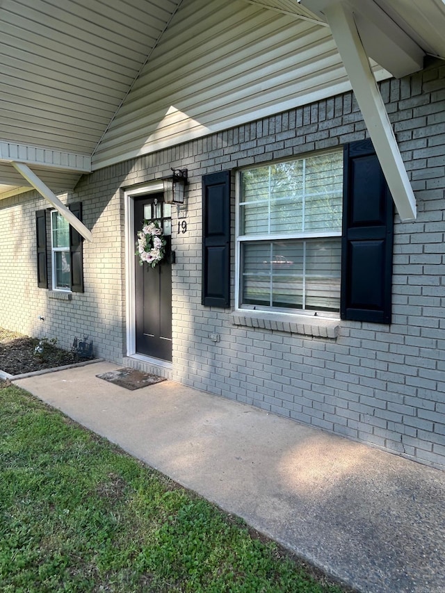 entrance to property featuring brick siding
