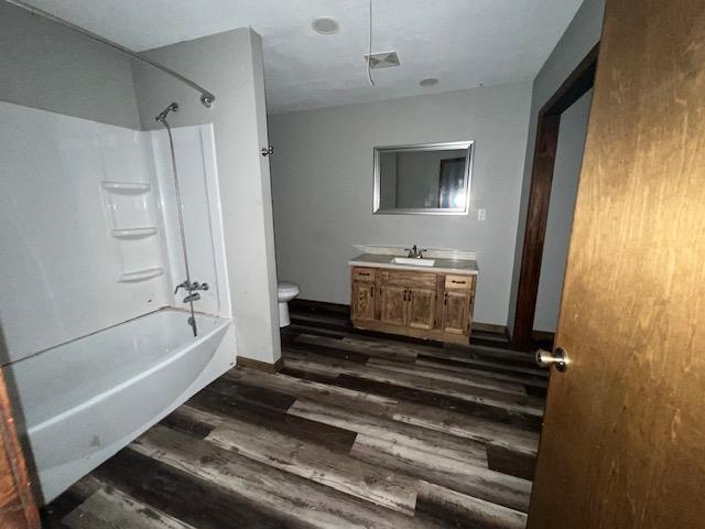 12326 Renshaw Ln, Trumann, AR 72401 - bathroom featuring shower / bathing tub combination, wood finished floors, toilet, and vanity