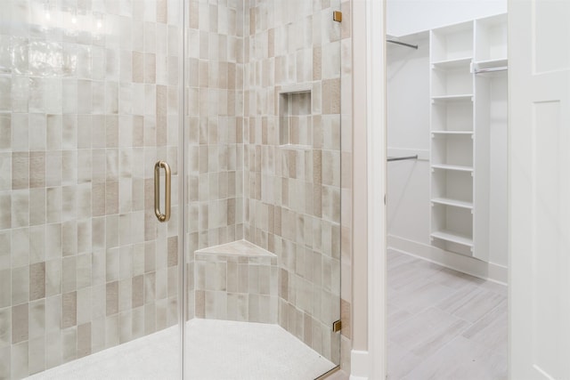 full bath featuring a spacious closet and a stall shower