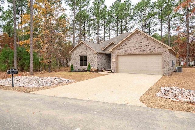 view of front of home featuring cooling unit, driveway, a garage, and brick siding