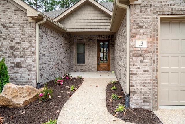 property entrance featuring brick siding and a garage