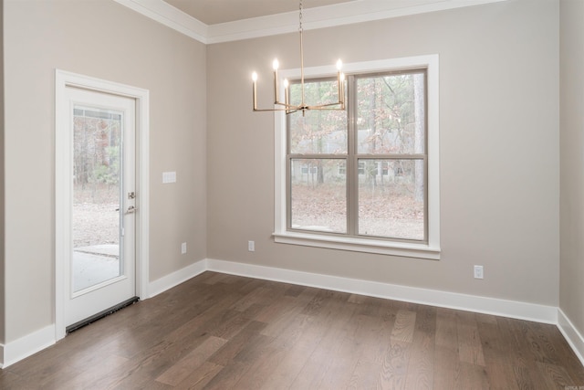 unfurnished dining area featuring crown molding, a notable chandelier, dark wood-style floors, and baseboards