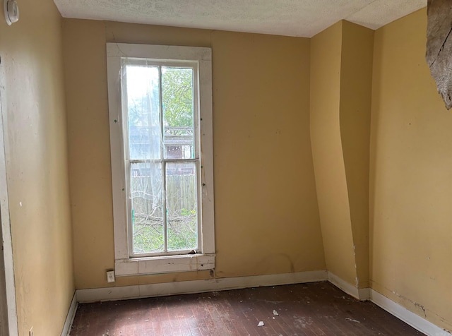307 E Center Ave, Searcy, AR 72143 - unfurnished room with wood-type flooring, a textured ceiling, and a wealth of natural light