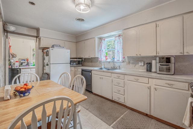 kitchen with appliances with stainless steel finishes, tasteful backsplash, light countertops, and a sink