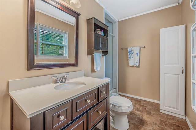 bathroom featuring stone finish floor, toilet, vanity, baseboards, and crown molding