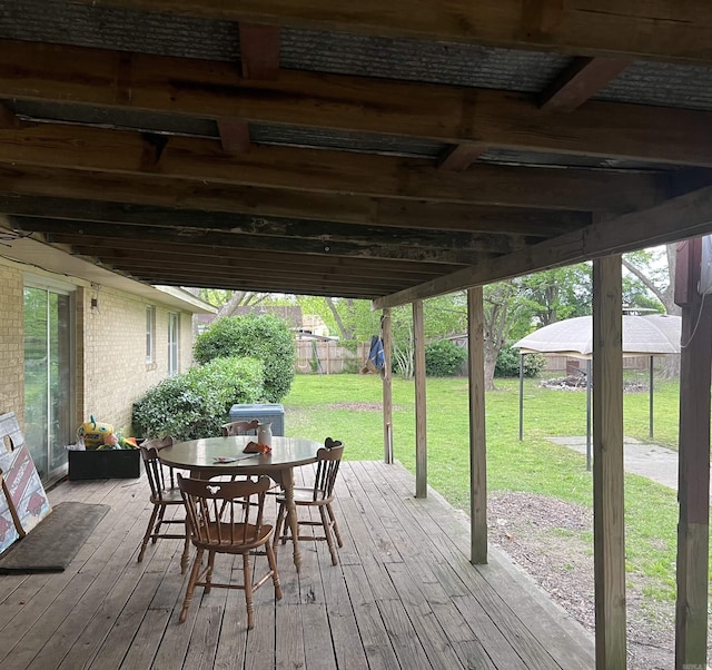 190 E Poplar St, Piggott, AR 72454 - deck featuring fence, outdoor dining area, and a lawn