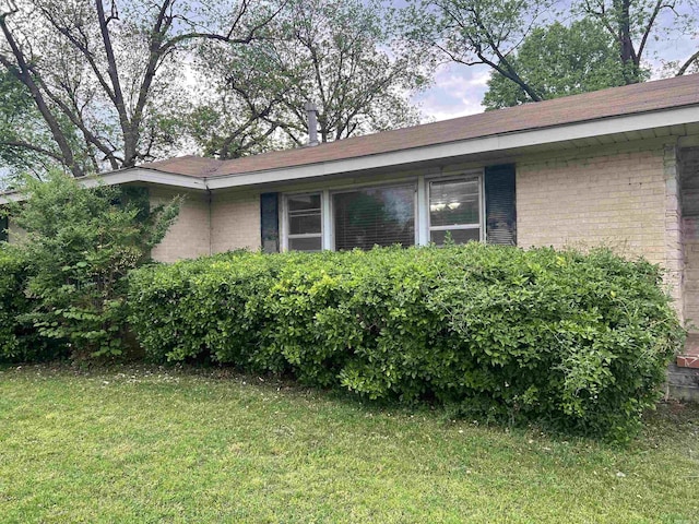 190 E Poplar St, Piggott, AR 72454 - view of property exterior featuring brick siding and a yard