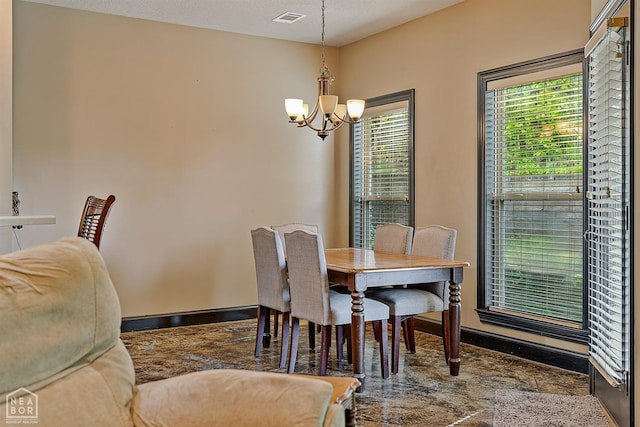 dining room featuring a wealth of natural light, visible vents, a notable chandelier, and baseboards