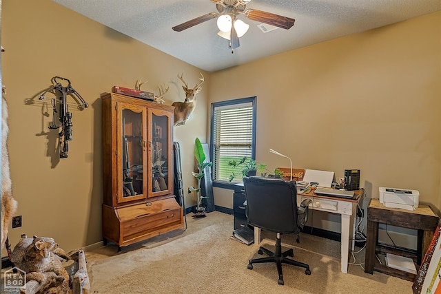 office space with a textured ceiling, ceiling fan, light colored carpet, and baseboards