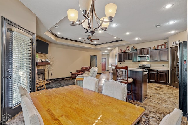 dining room with visible vents, a raised ceiling, ceiling fan with notable chandelier, and recessed lighting