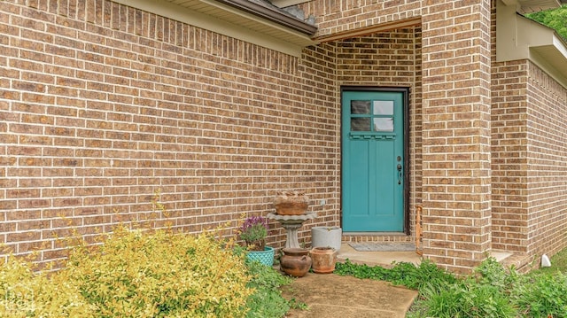 entrance to property featuring brick siding