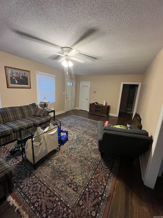 living area featuring a ceiling fan, baseboards, and a textured ceiling