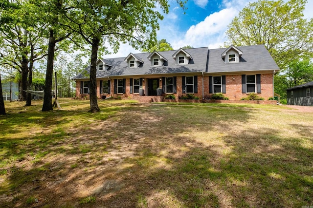 cape cod home featuring a front lawn and brick siding