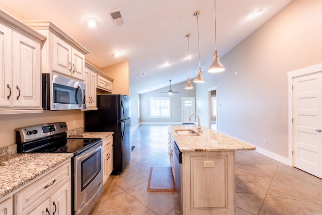 kitchen with a kitchen island with sink, a sink, stainless steel appliances, cream cabinetry, and lofted ceiling