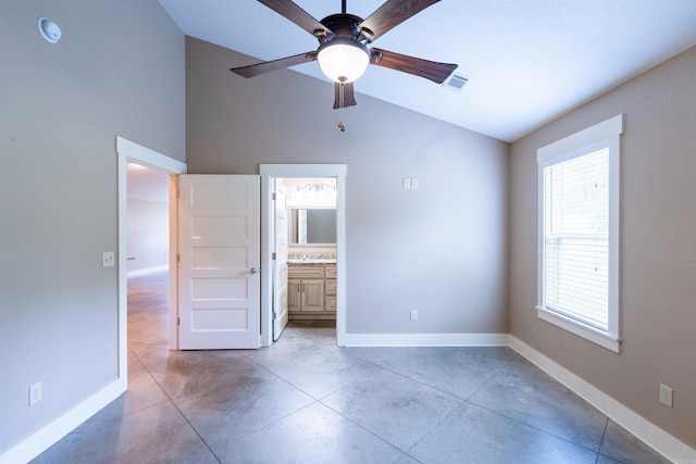 unfurnished bedroom featuring lofted ceiling, finished concrete flooring, connected bathroom, visible vents, and baseboards