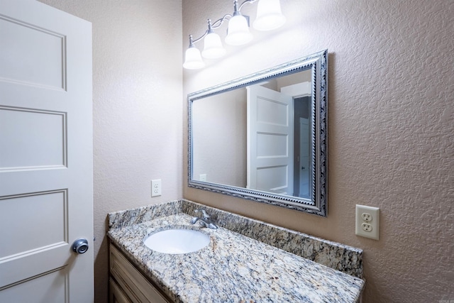 bathroom featuring a textured wall and vanity