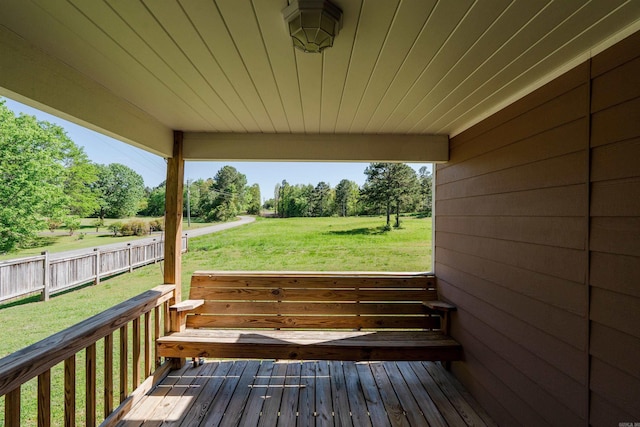 wooden terrace featuring fence and a yard