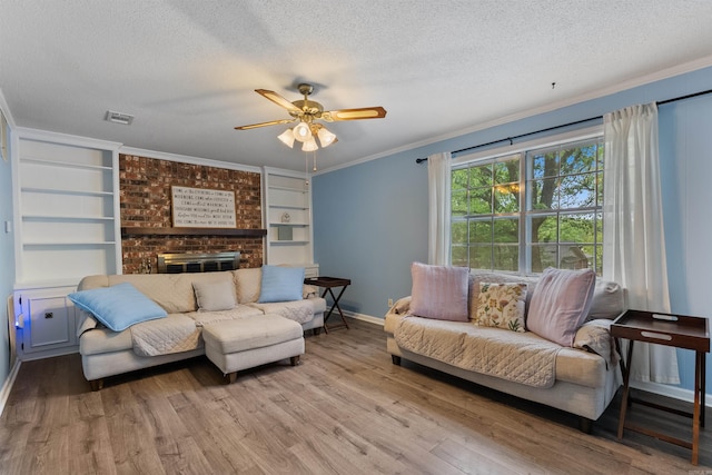 living room featuring a textured ceiling, visible vents, and wood finished floors