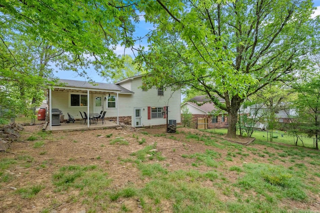 rear view of house featuring a patio, fence, and central AC