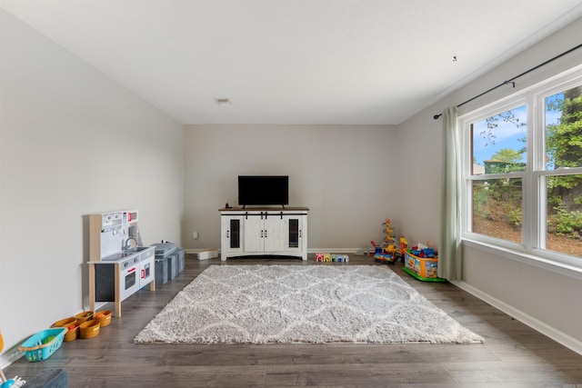 rec room with baseboards, visible vents, and wood finished floors