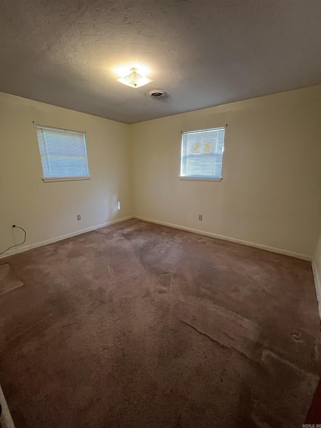 904 Belmont Dr, Pine Bluff, AR 71601 - empty room with a textured ceiling, visible vents, carpet flooring, and baseboards