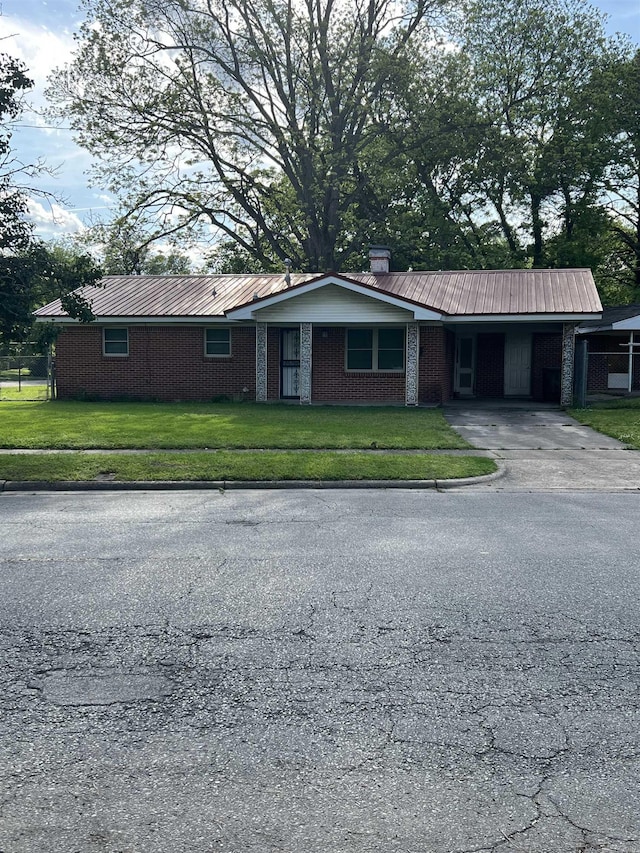 904 Belmont Dr, Pine Bluff, AR 71601 - ranch-style home featuring driveway, a carport, metal roof, a front lawn, and brick siding